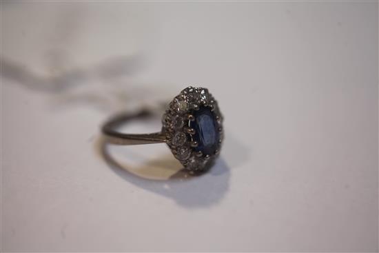 An 18ct white gold, sapphire and diamond oval cluster ring, size K.